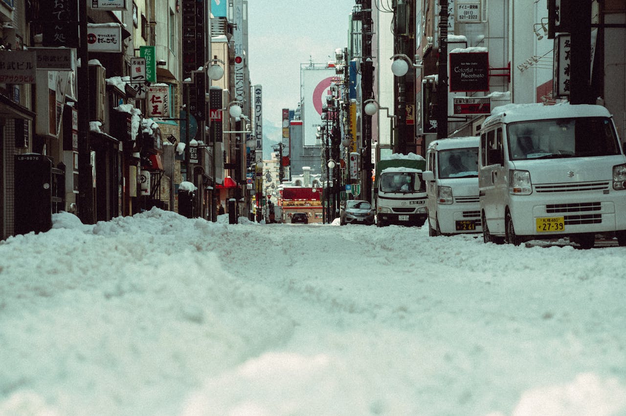 Winter street scene covered in snow, capturing the urban atmosphere of Hokkaido, Japan.