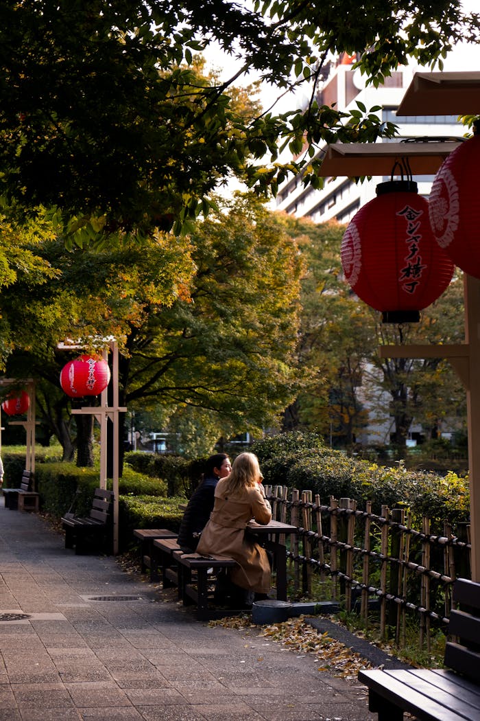 Couple enjoying a peaceful moment in a garden adorned with traditional Japanese lanterns.