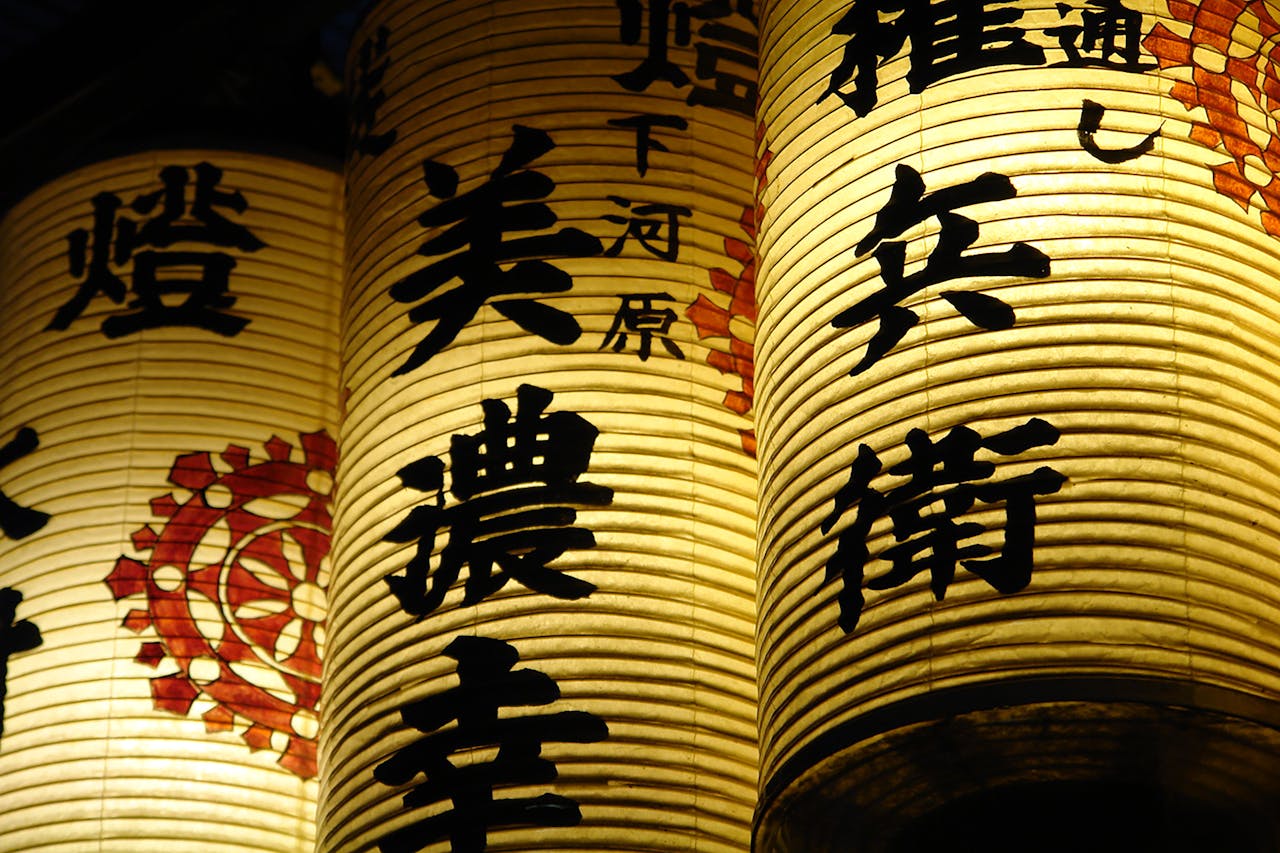 Beautifully lit traditional lanterns with kanji script in Kyoto, Japan.