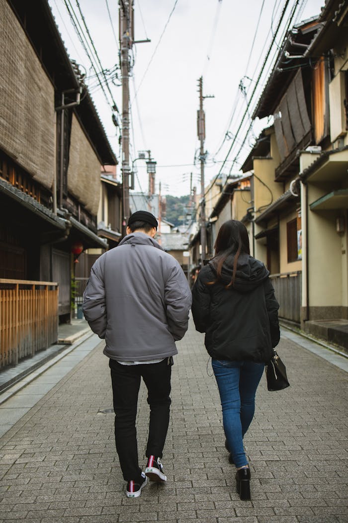 A young couple strolls through the traditional streets of Gion, Kyoto. Experience the serene ambiance and historic charm.